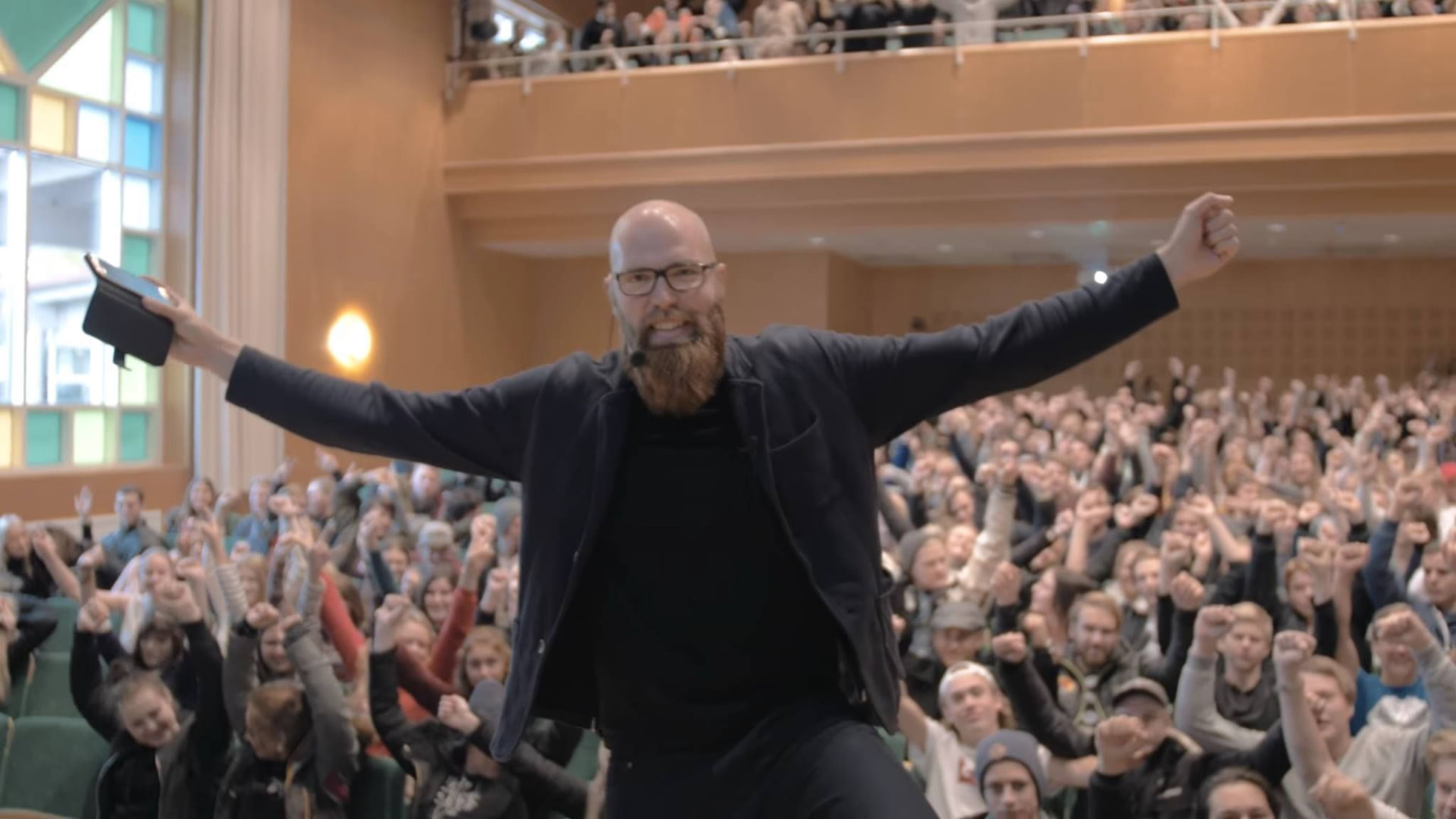 Eric Bergström på scen med utsträckta armar framför en jublande publik